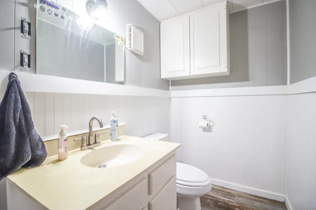 a bathroom with a sink toilet and a mirror