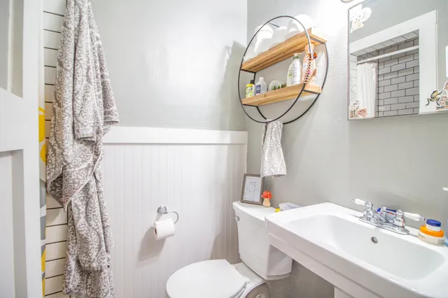 a bathroom with a sink a toilet and a mirror