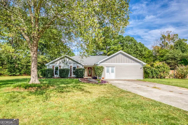 a front view of a house with a yard and trees