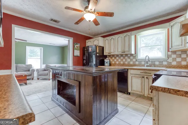 a kitchen with kitchen island granite countertop wooden cabinets a sink and a stove