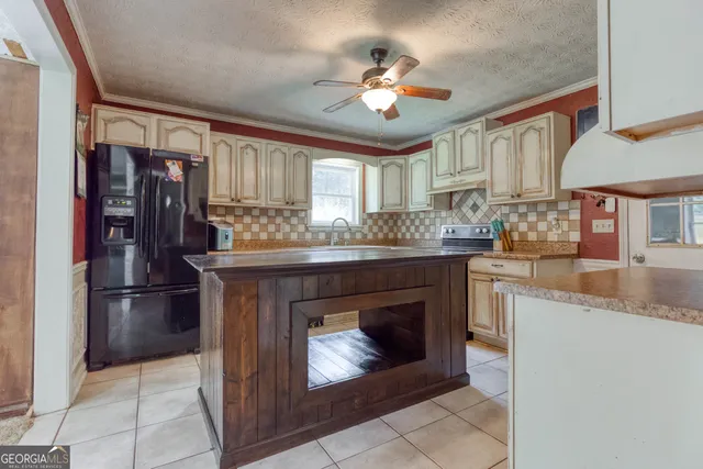 a kitchen with granite countertop stainless steel appliances a stove refrigerator and cabinets