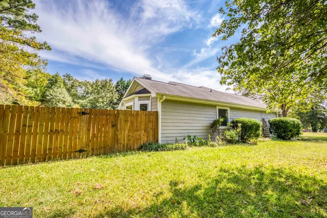 a view of backyard of house with green space