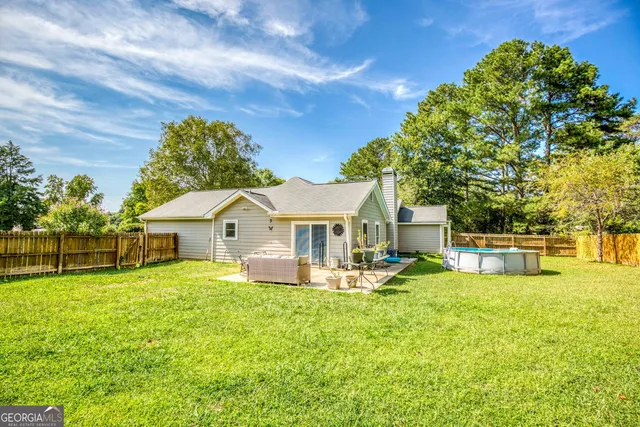 a view of a house with a big yard and large trees