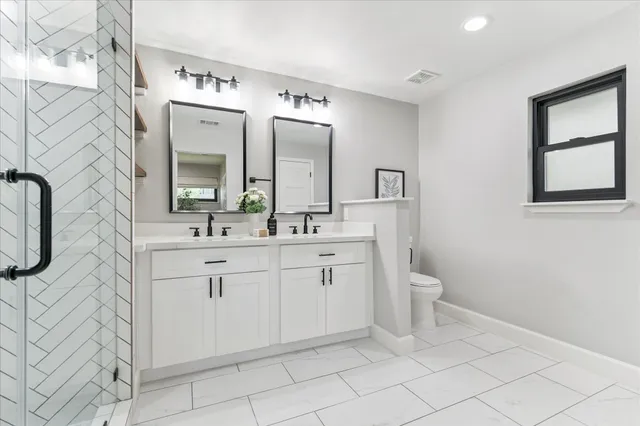 a spacious bathroom with a toilet sink and mirror