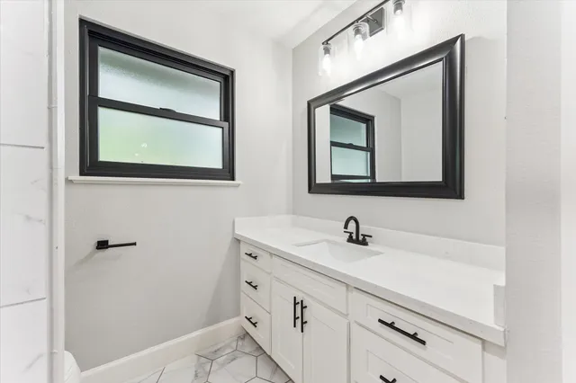 a bathroom with a sink mirror and vanity