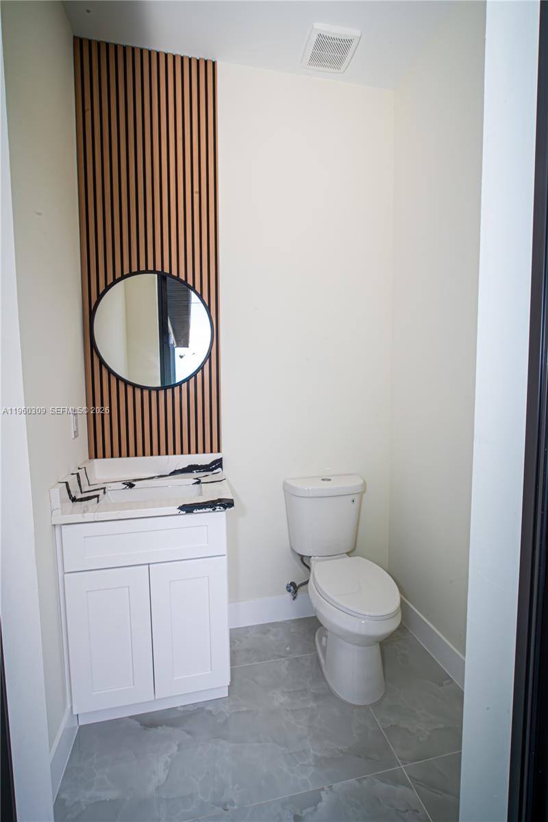 2903 East 17th Street Lehigh Acres, FL 33972 - Photo 17 of 34 a bathroom with a granite countertop toilet and a sink