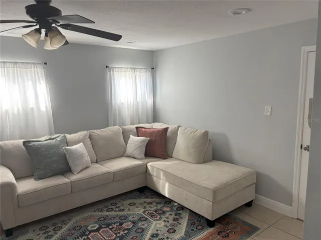 a living room with furniture and a ceiling fan
