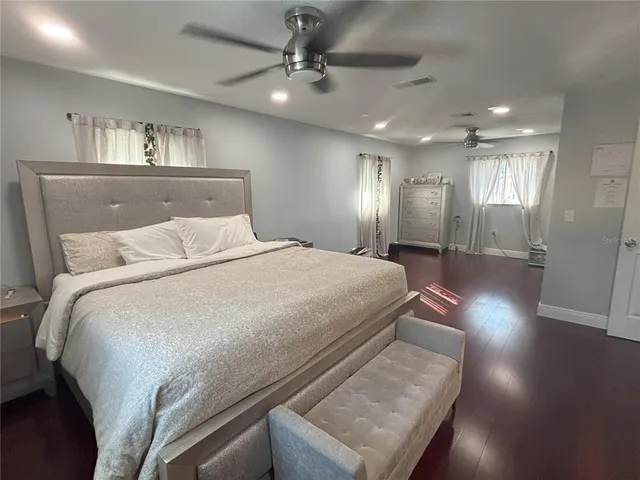 a spacious bedroom with a bed and a chandelier