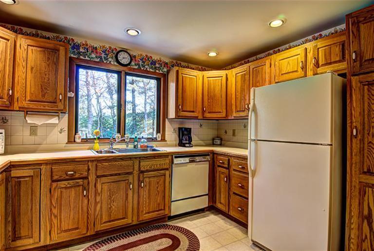 80 Sea Robin Road Osterville, MA 02655 - Photo 11 of 20 a kitchen with a refrigerator a sink and cabinets