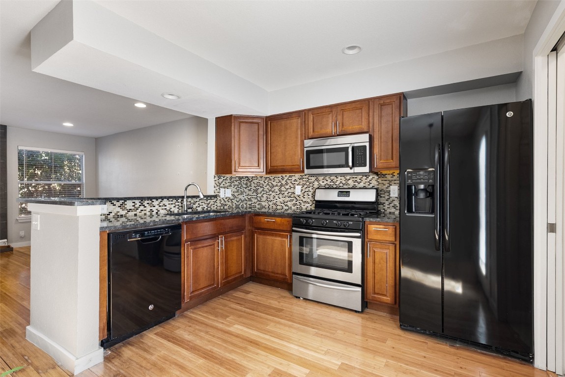 3601 Menchaca Road, Unit 117 Austin, TX 78704 - Photo 9 of 29 a kitchen with granite countertop stainless steel appliances and wooden cabinets