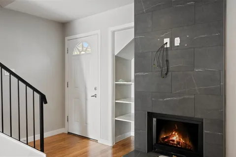 a view of a hallway with wooden floor and a fireplace