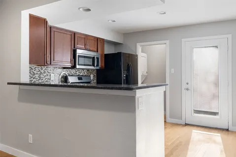a kitchen with stainless steel appliances granite countertop a refrigerator and a microwave