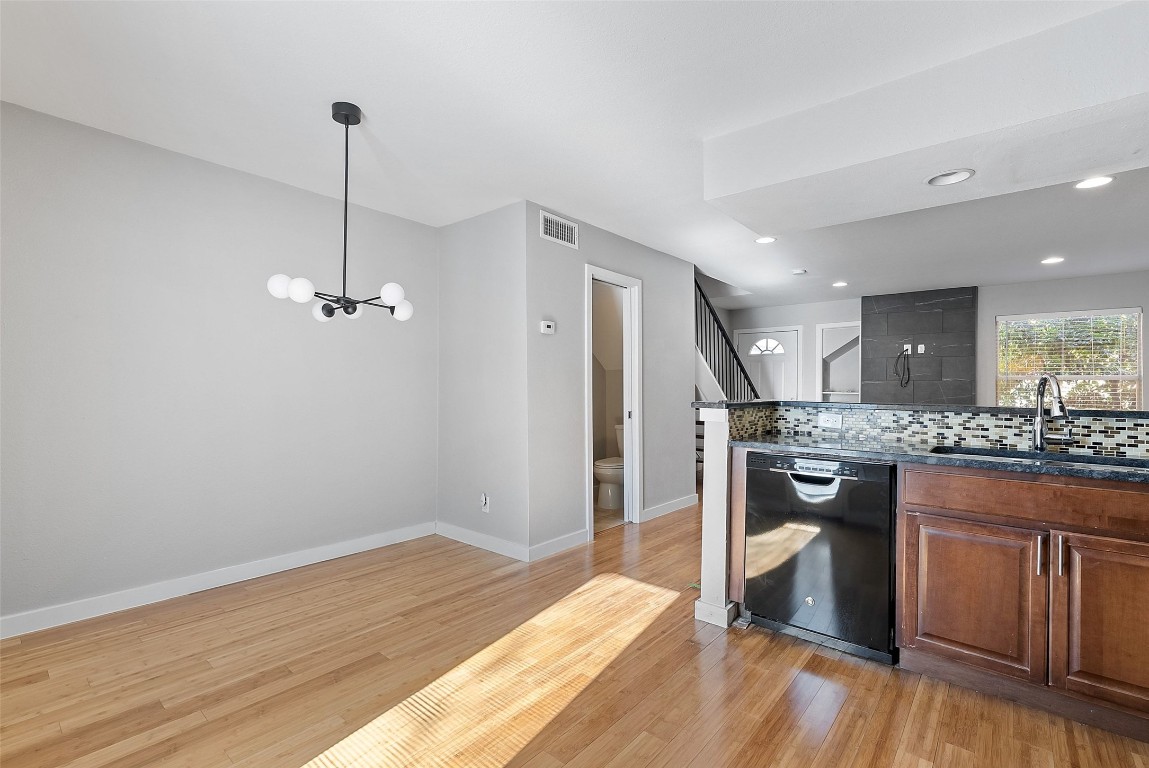3601 Menchaca Road, Unit 117 Austin, TX 78704 - Photo 7 of 25 a kitchen with kitchen island a stove and wooden floor