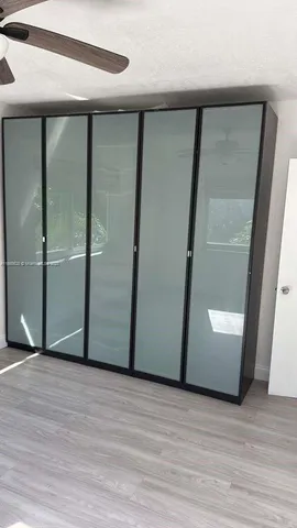 a view of an empty room with wooden floor and door