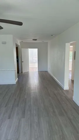 a view of a big room with wooden floor and windows