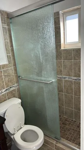 a white toilet sitting next to a shower