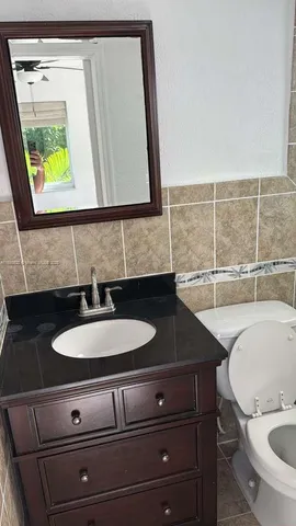 a bathroom with a granite countertop sink and a mirror
