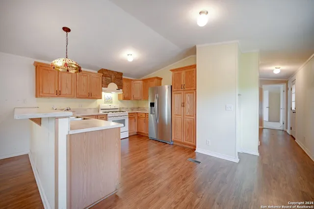 a view of a kitchen with a sink and wooden floor