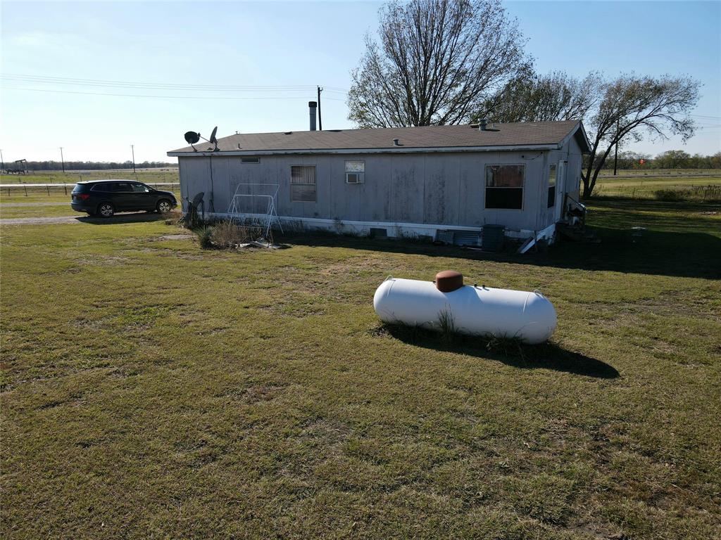 16531 Farm To Market 455 Pilot Point, TX 76258 - Photo 19 of 37 Rear view of house featuring a lawn