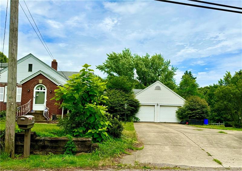 616 Sandy Hill Road Irwin, PA 15642 - Photo 3 of 38 a front view of a house with a yard and garage