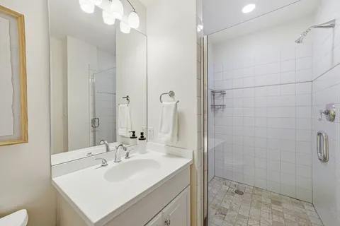 a bathroom with a sink shower and a mirror