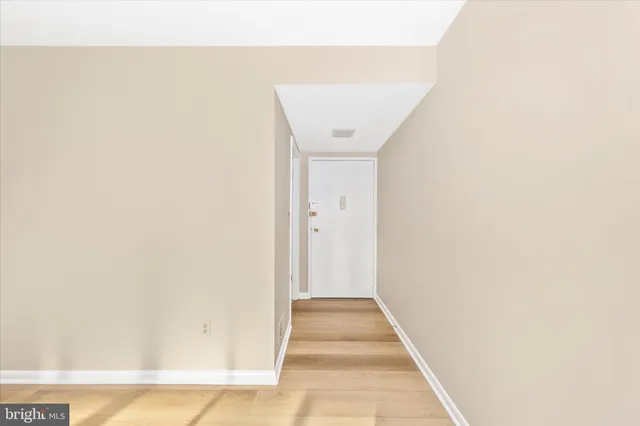 a view of a hallway with wooden floor
