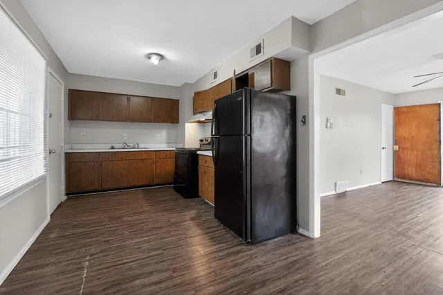 an empty room with windows and fan