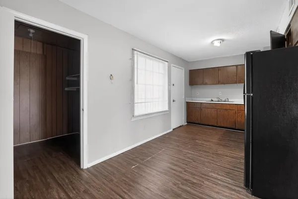 a kitchen with stainless steel appliances granite countertop wooden cabinets a stove top oven a sink and dishwasher with wooden floor