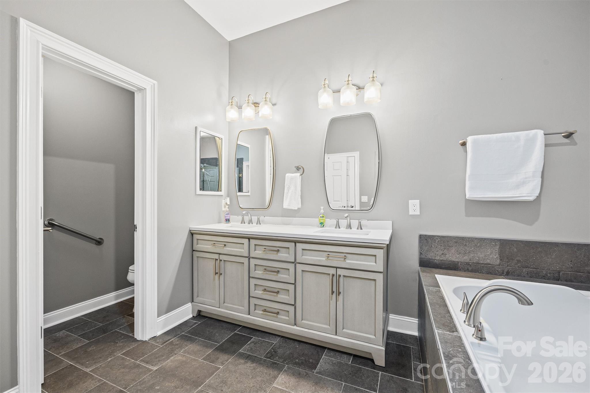 2578 Lower Assembly Drive Fort Mill, SC 29708 - Photo 16 of 28 a spacious bathroom with a granite countertop sink and a mirror