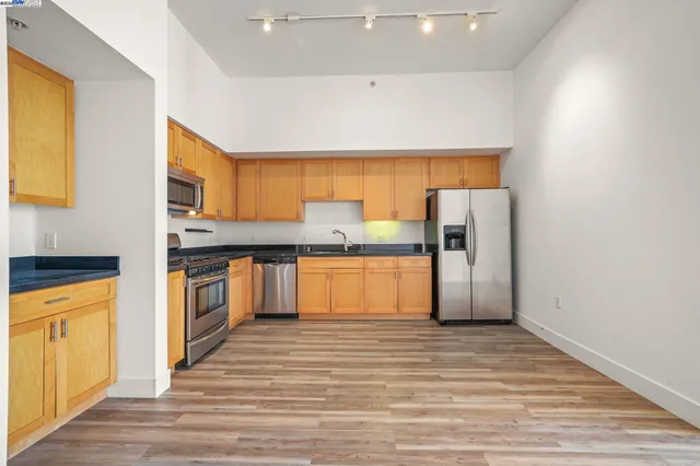 a kitchen with stainless steel appliances granite countertop a refrigerator and a stove top oven