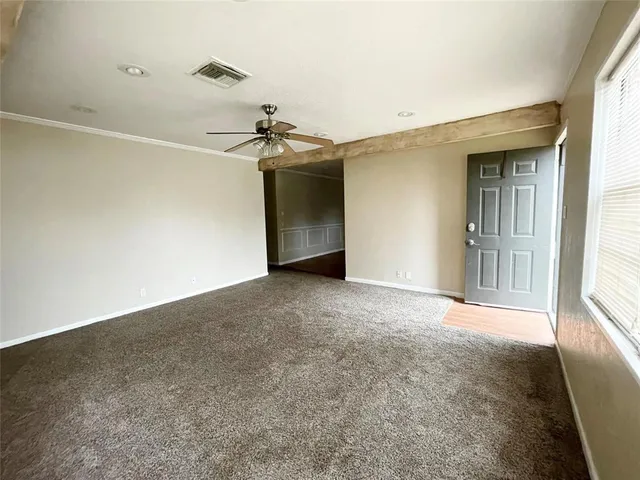 a view of a livingroom with a ceiling fan and window