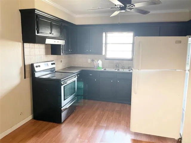 a kitchen with a sink a stove and a refrigerator