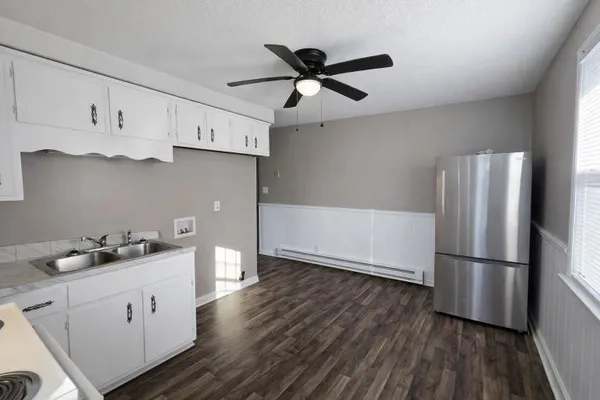 a kitchen with cabinets and wooden floor