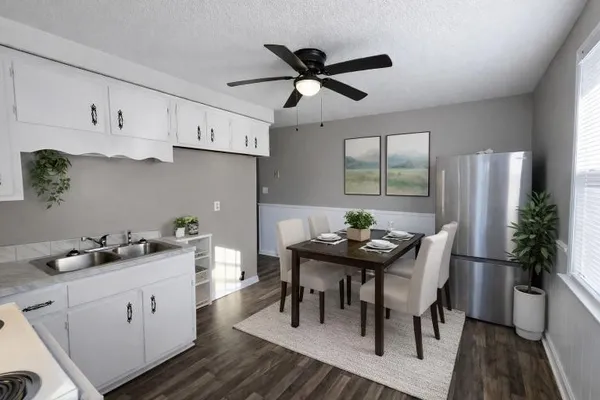 a kitchen with stainless steel appliances kitchen island granite countertop a table chairs in it and wooden floors