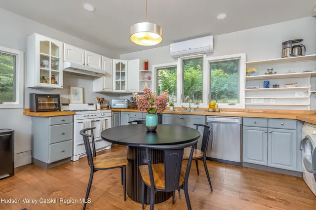 a bedroom with a bed and dresser with wooden floor