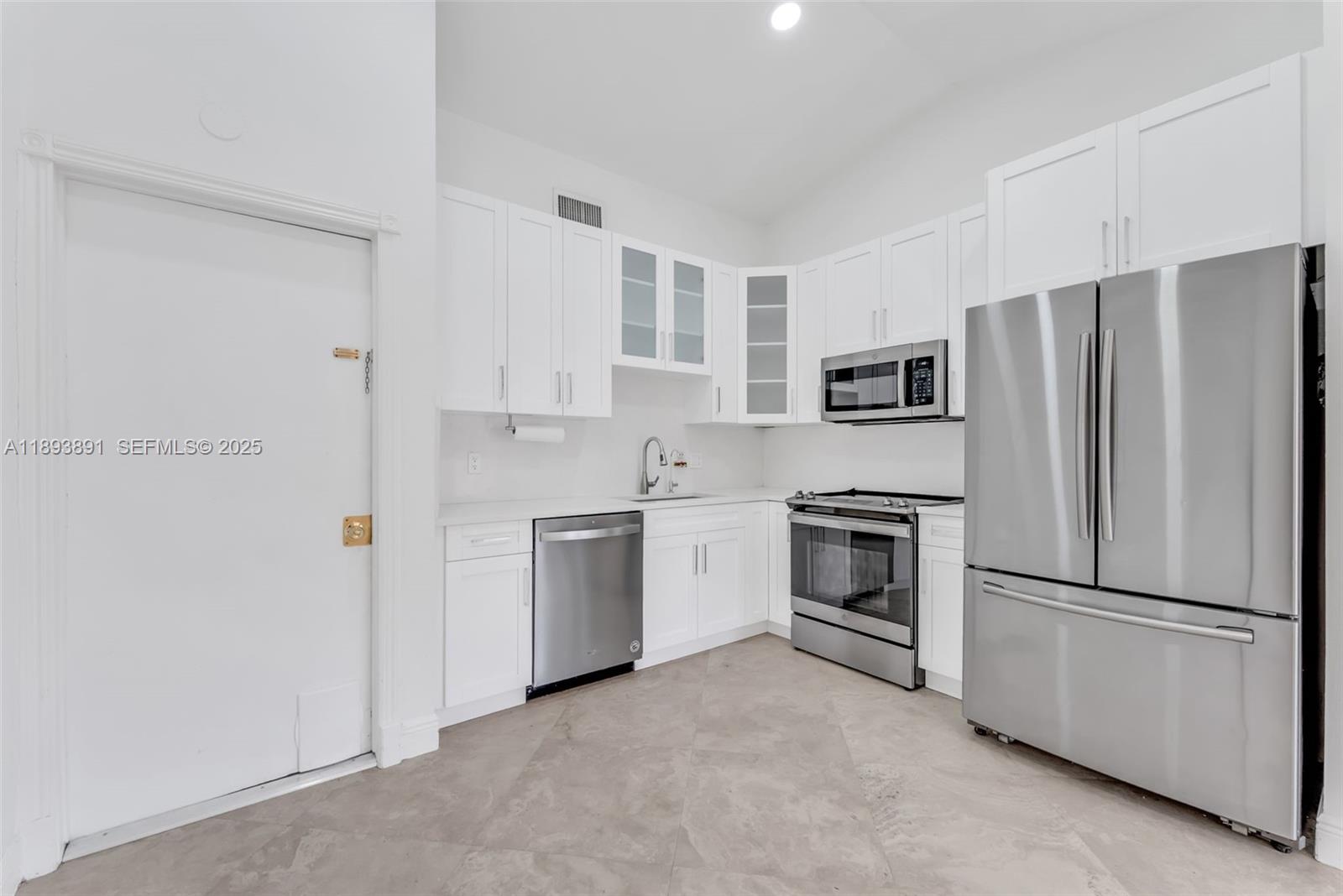 9801 Ridge Creek Road Boca Raton, FL 33496 - Photo 11 of 54 a kitchen with stainless steel appliances white cabinets and a refrigerator