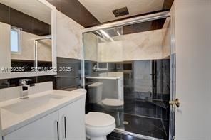 9801 Ridge Creek Road Boca Raton, FL 33496 - Photo 31 of 54 a bathroom with a sink a toilet and a mirror