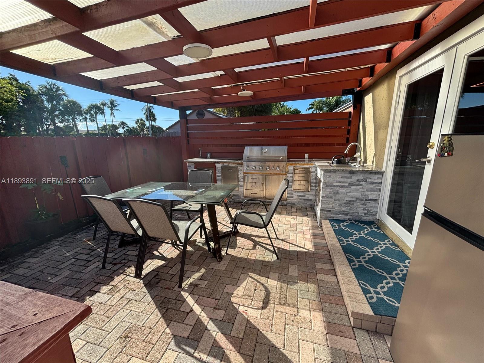 9801 Ridge Creek Road Boca Raton, FL 33496 - Photo 41 of 54 a view of a backyard with table and chairs with wooden floor