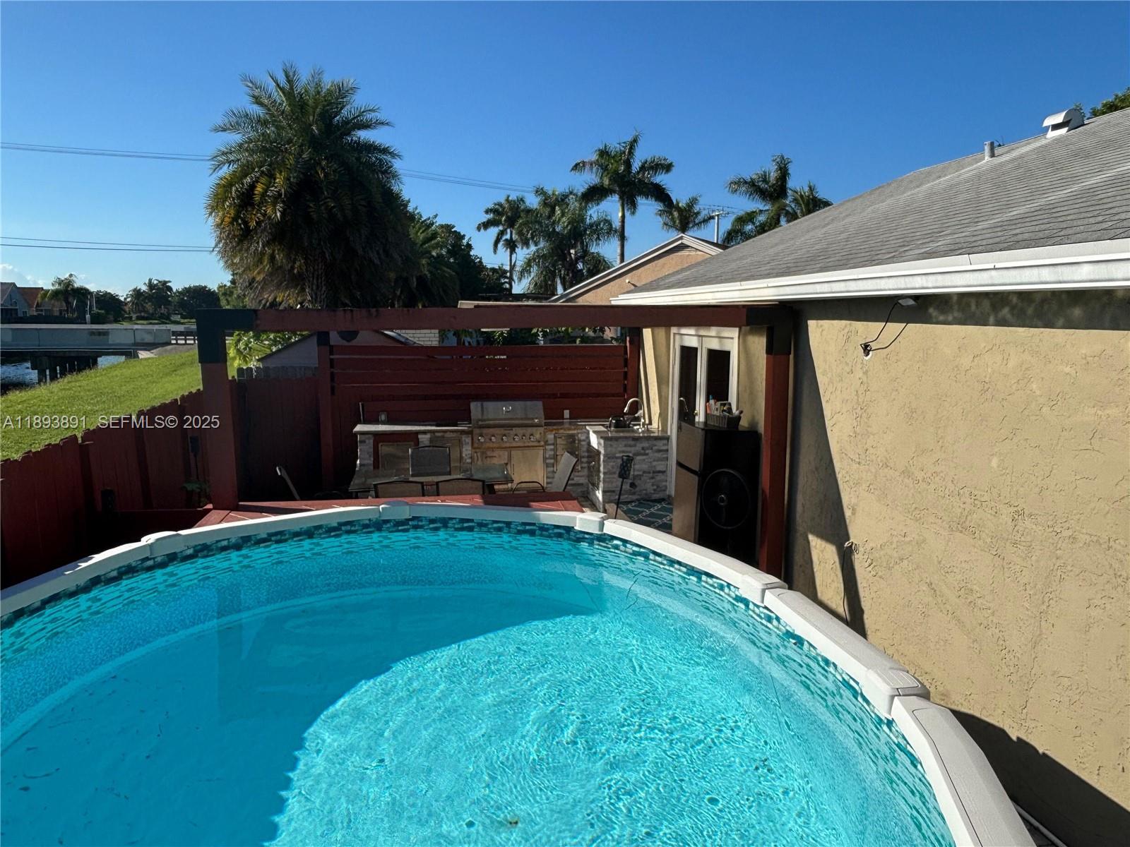 9801 Ridge Creek Road Boca Raton, FL 33496 - Photo 42 of 54 a backyard of a house with table and sofas