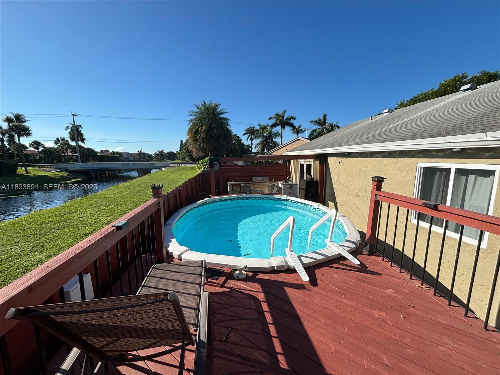 9801 Ridge Creek Road Boca Raton, FL 33496 - Photo 43 of 54 a view of a chairs and table on the wooden deck
