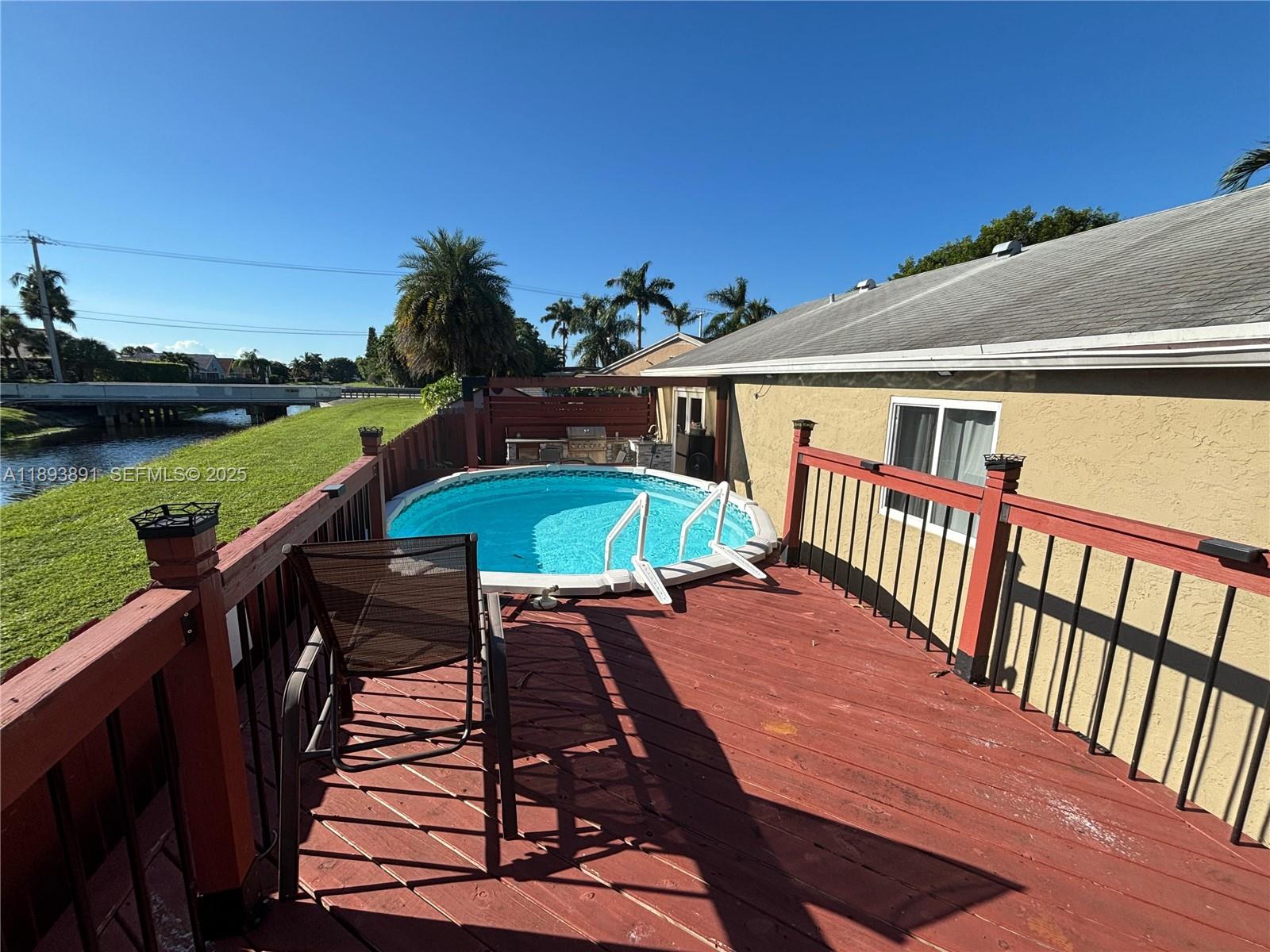 9801 Ridge Creek Road Boca Raton, FL 33496 - Photo 44 of 54 a balcony with wooden floor table and chairs