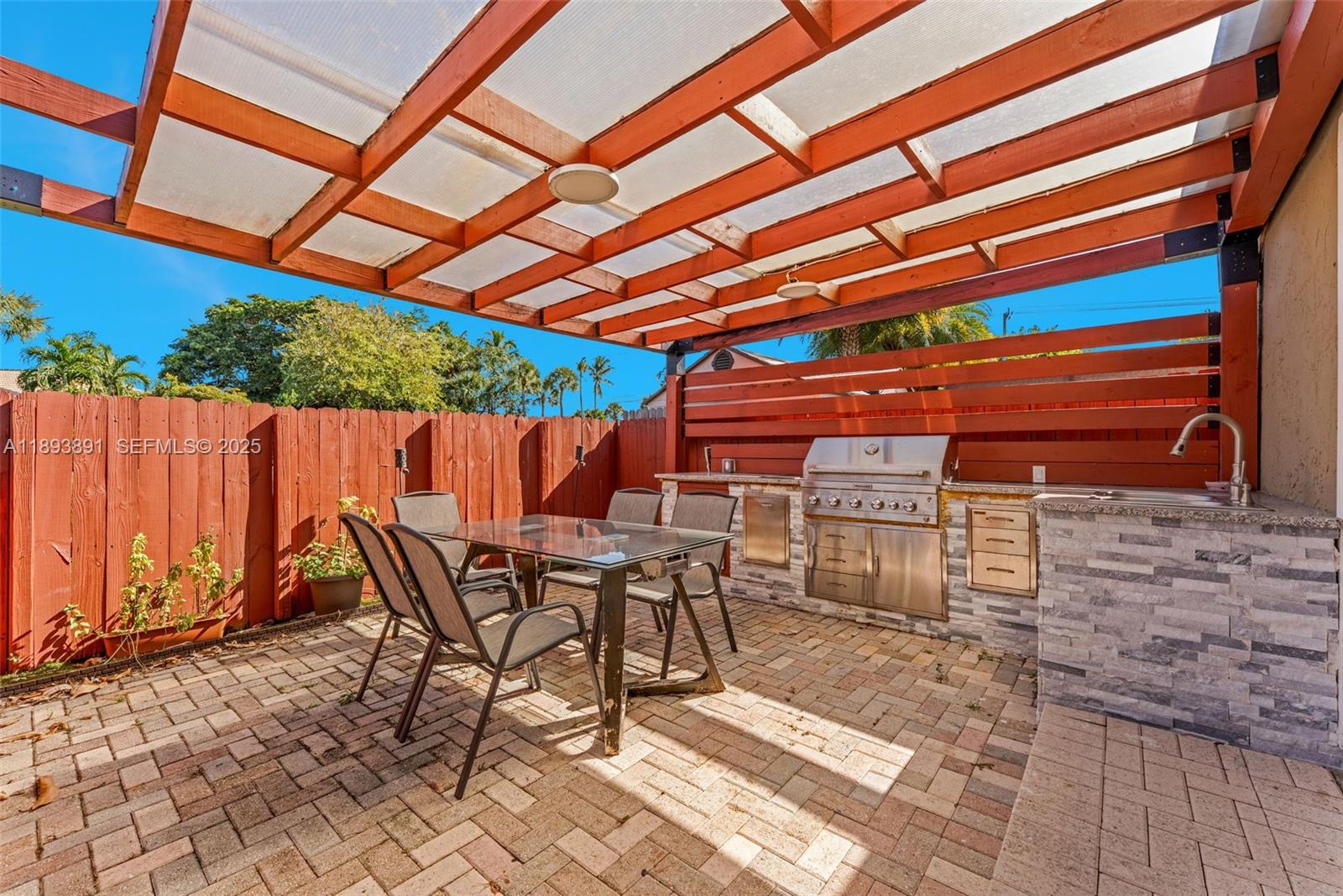 9801 Ridge Creek Road Boca Raton, FL 33496 - Photo 47 of 54 a patio with wooden cabinets and outdoor space