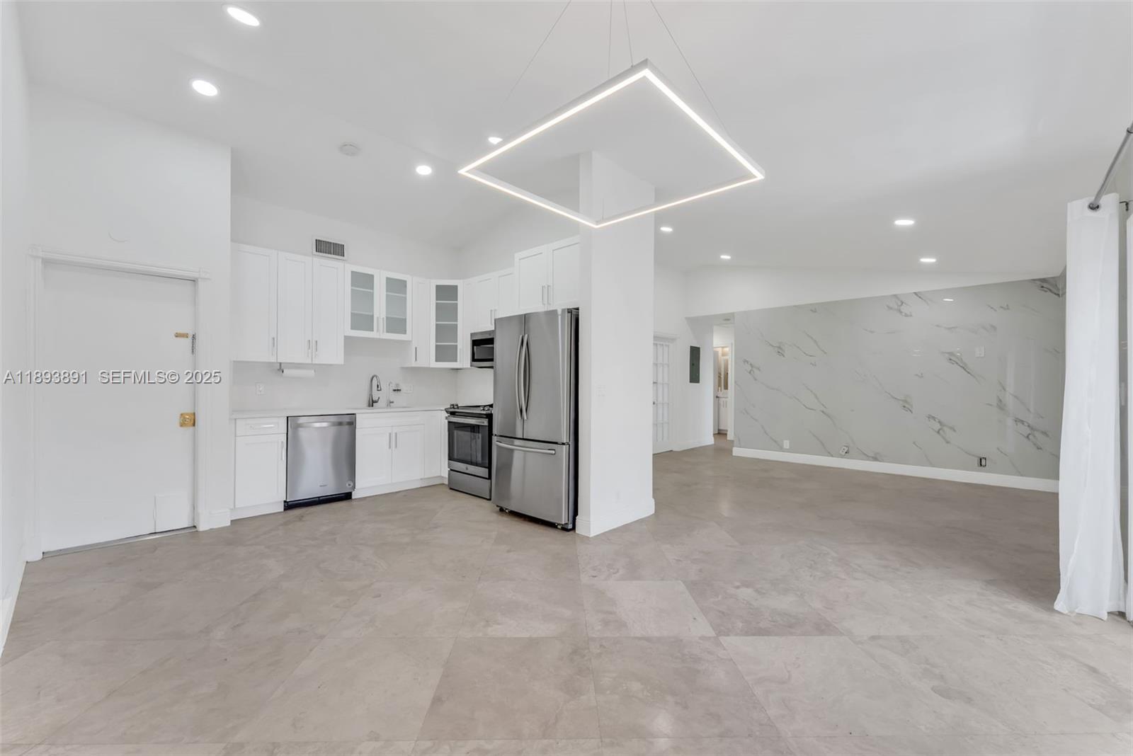 9801 Ridge Creek Road Boca Raton, FL 33496 - Photo 8 of 54 a view of a kitchen with refrigerator and white cabinets