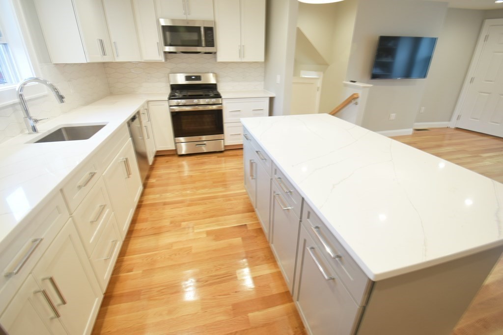 a kitchen with granite countertop a sink and a stove