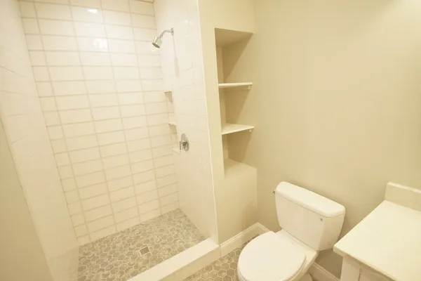 a white toilet sitting next to a shower
