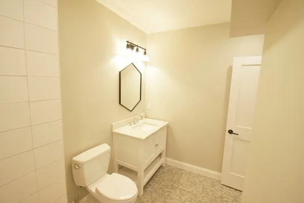 a bathroom with a toilet sink and mirror