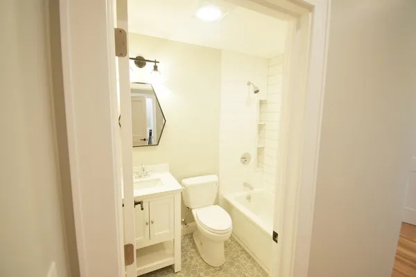 a bathroom with a granite countertop toilet and a shower
