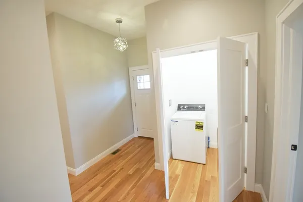 a view of a hallway with wooden floor and closet