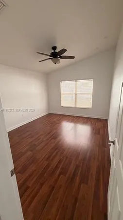 a view of a room with wooden floor and a ceiling fan