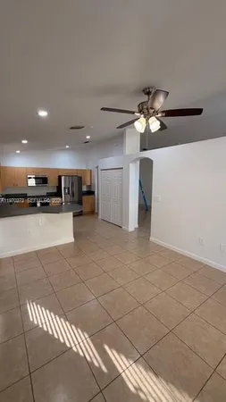 a kitchen with granite countertop a refrigerator and a stove top oven